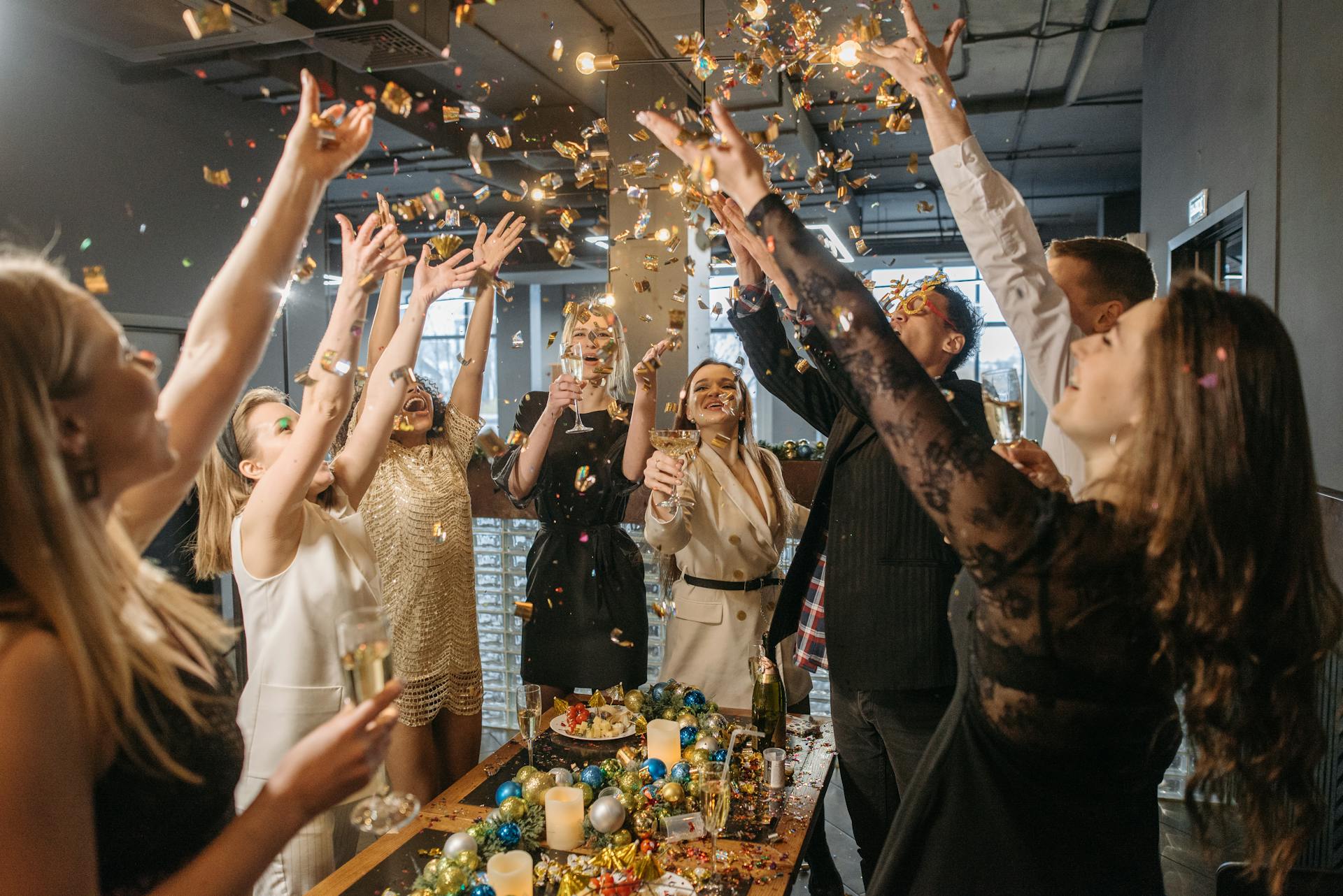 a group of people standing around a table celebrating