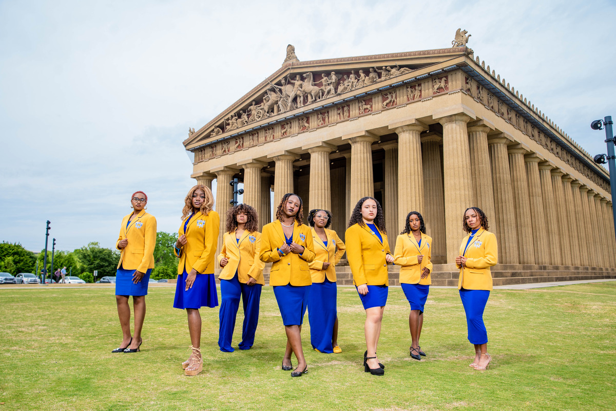 group shot of women wearing blue and yellow posing in front of an old building taken by Nashville Corporate Media